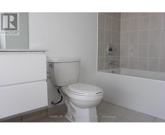 A white toilet in a bathroom with a bathtub and a shower.