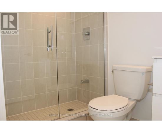 A white toilet in a bathroom with a glass shower door.