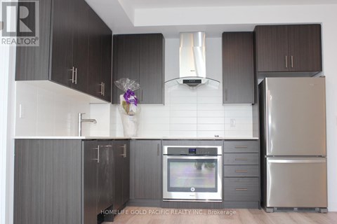 A modern kitchen with dark brown cabinets and stainless steel appliances.