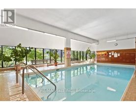 A large indoor swimming pool with a glass wall on one side.
