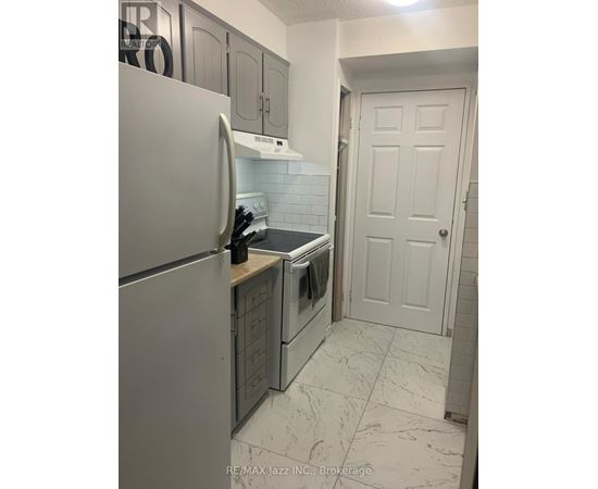 A kitchen with a white refrigerator and a white door.
