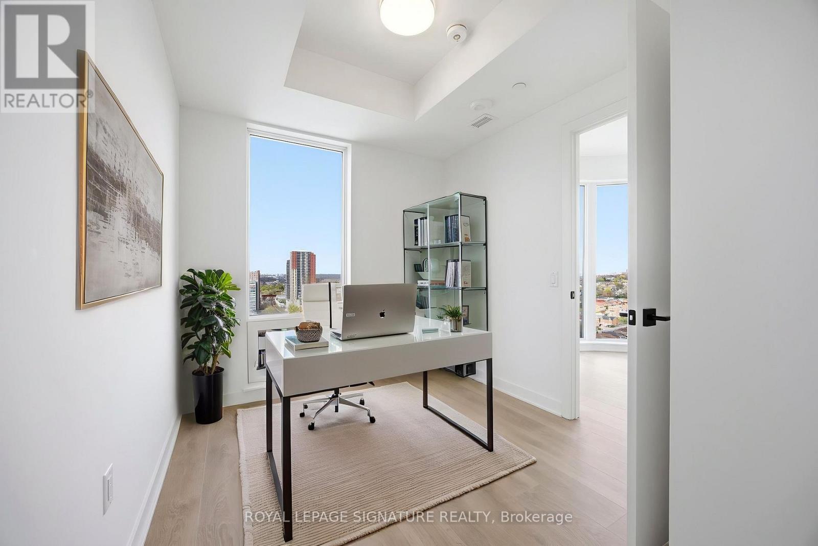 A room with a desk and a plant.