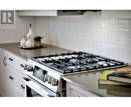 A modern kitchen with a stove top oven and a book on the counter.