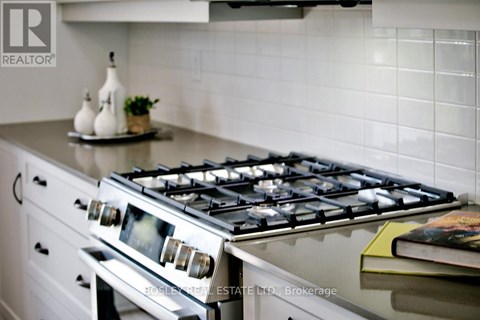 A modern kitchen with a stove top oven and a book on the counter.