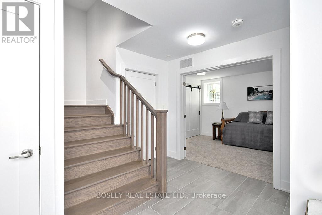 A real estate listing photo of a bedroom with a staircase.