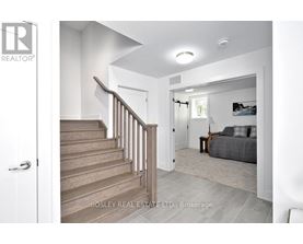A real estate listing photo of a bedroom with a staircase.