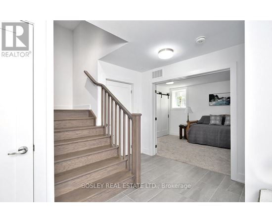 A real estate listing photo of a bedroom with a staircase.