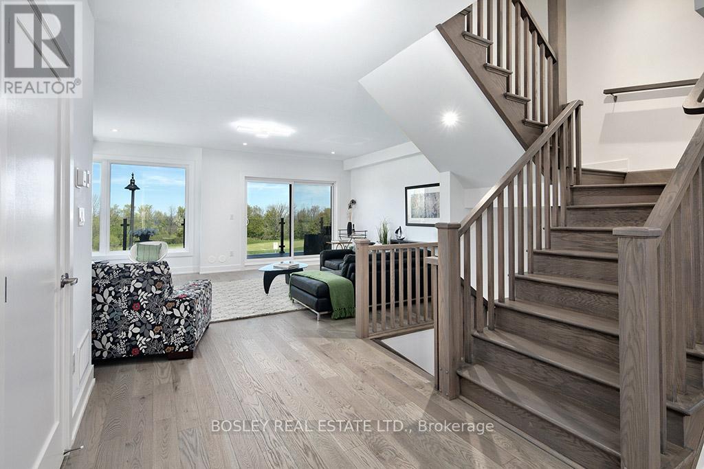 A spacious living room with a staircase leading to the upper floor.