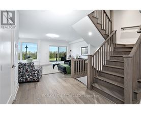 A spacious living room with a staircase leading to the upper floor.
