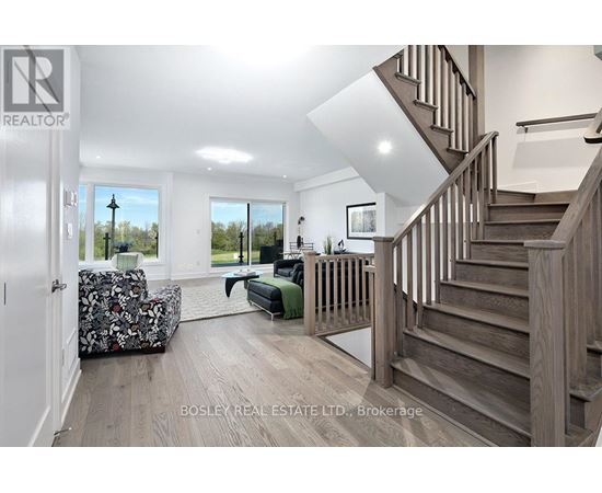 A spacious living room with a staircase leading to the upper floor.