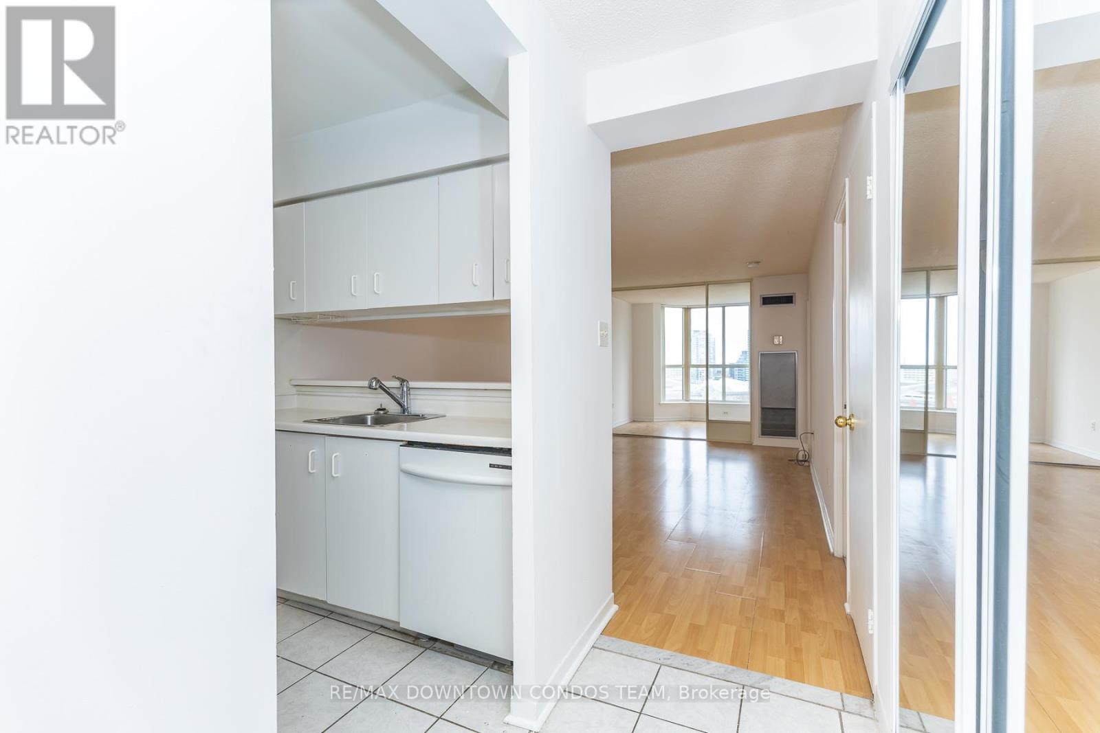 A white kitchen with a sink and cabinets.
