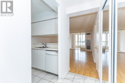 A white kitchen with a sink and cabinets.