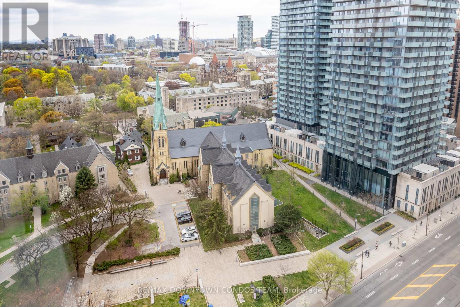 A view of a city with a church and a tall building in the background.