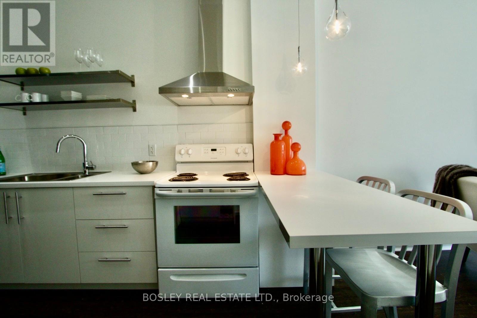 A kitchen with a stove top oven and a sink.