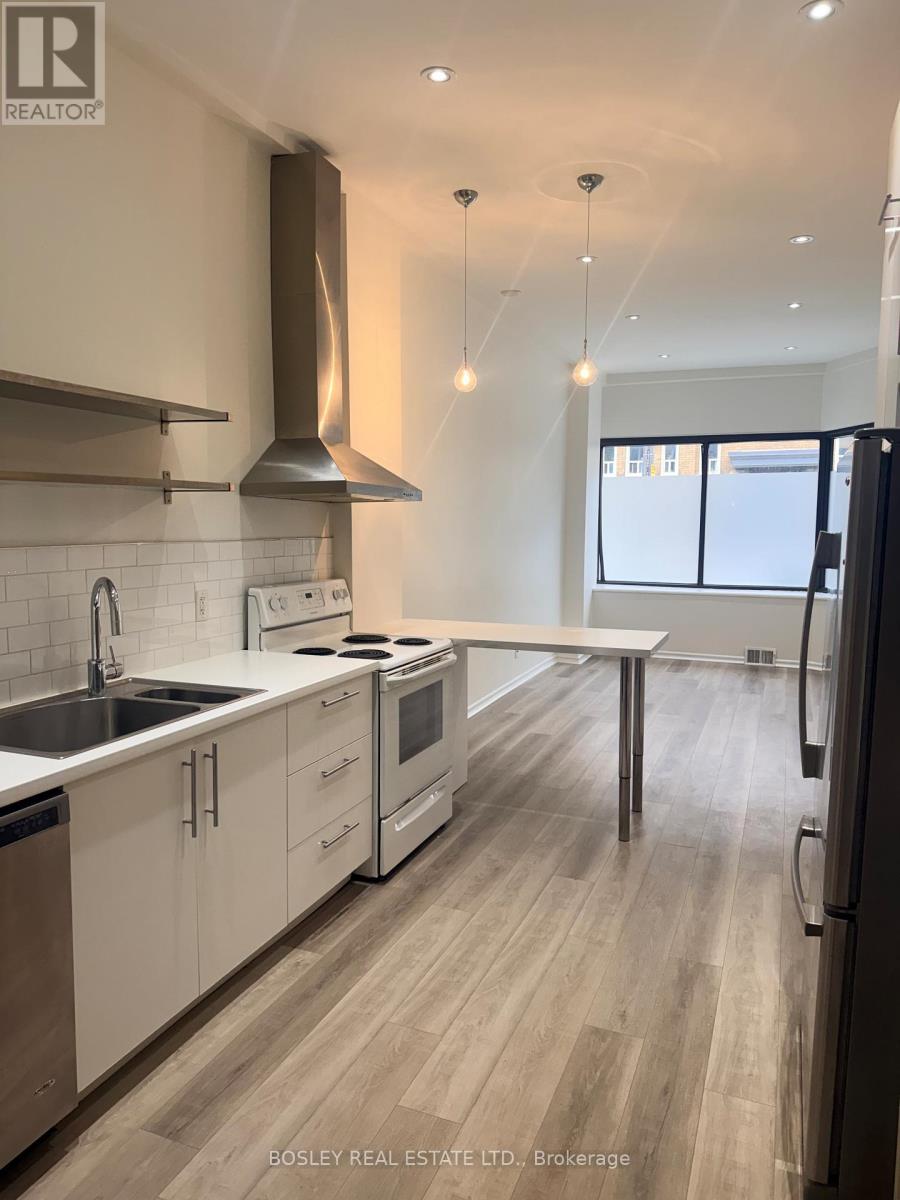 A modern kitchen with a stainless steel sink and white cabinets.