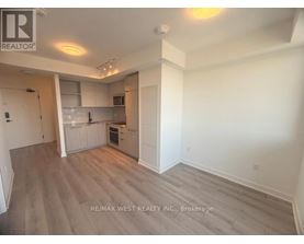 A spacious kitchen with white cabinets and a grey floor.