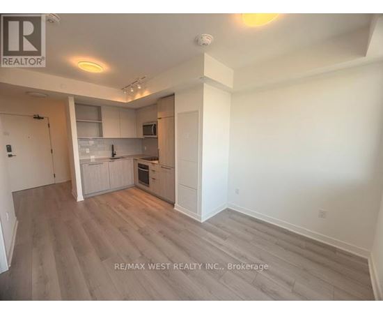 A spacious kitchen with white cabinets and a grey floor.