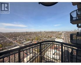 A balcony overlooks a cityscape with buildings and roads.
