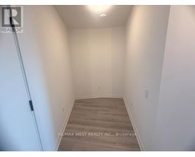 A hallway with wooden floors and white walls.