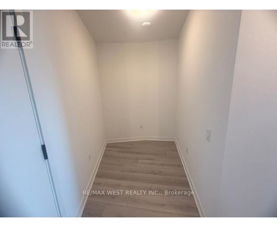 A hallway with wooden floors and white walls.