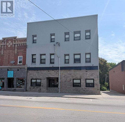 A grey building with a sign that says RE/MAX Grey Bruce Realty Inc. Brokerage.