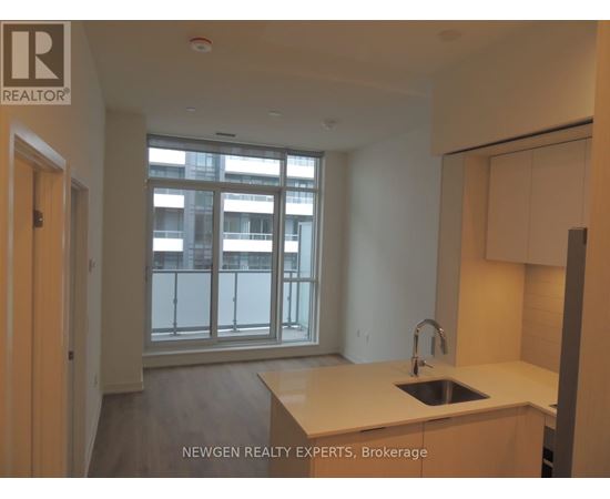 A kitchen with a sink and a window overlooking a balcony.
