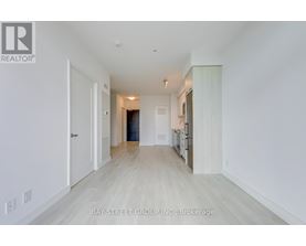 A spacious, empty room with white walls and a wooden floor.