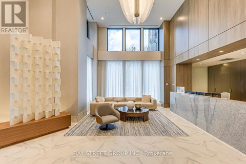A modern living room with a large white sculpture on the left side and a grey carpet on the floor.