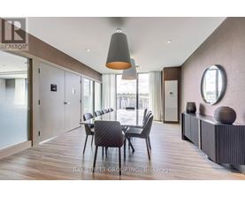 A modern dining room with a wooden floor and a large table with chairs.