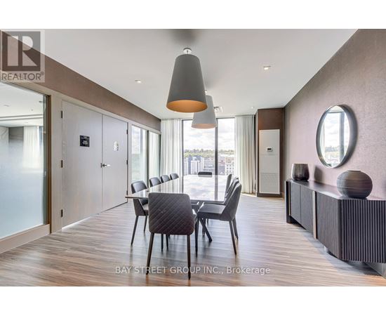 A modern dining room with a wooden floor and a large table with chairs.