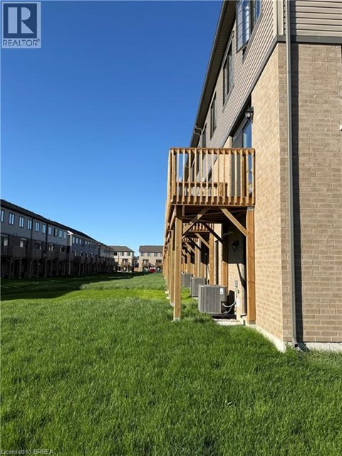 A wooden deck is attached to a brick building.