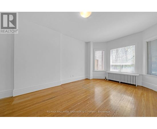 A spacious room with wooden floors and white walls.