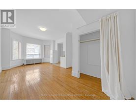 A spacious room with wooden floors and white walls.