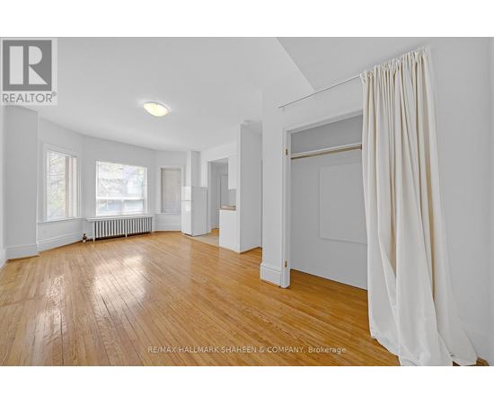 A spacious room with wooden floors and white walls.