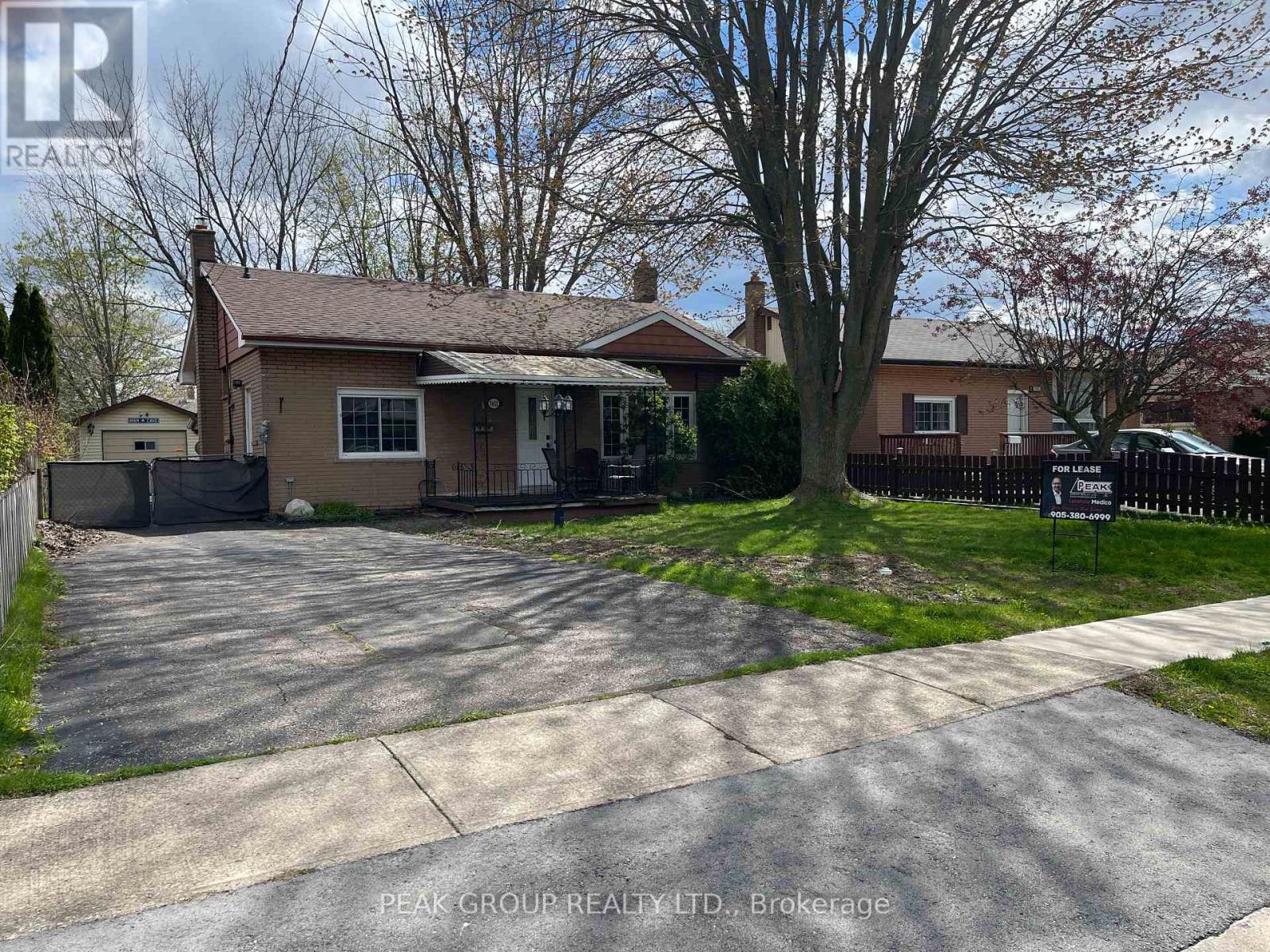 A house with a brown roof and a driveway in front of it.