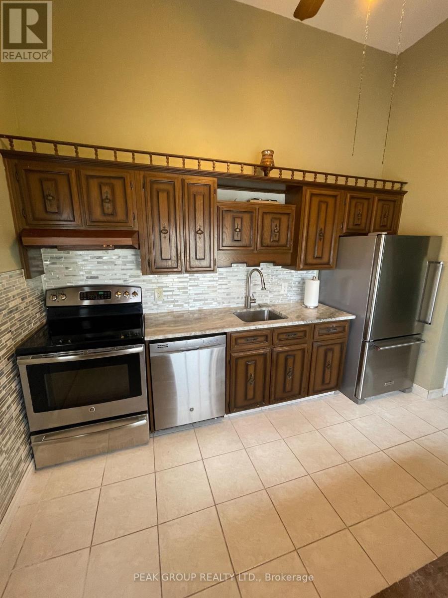 A kitchen with a stove, oven, sink, and refrigerator.