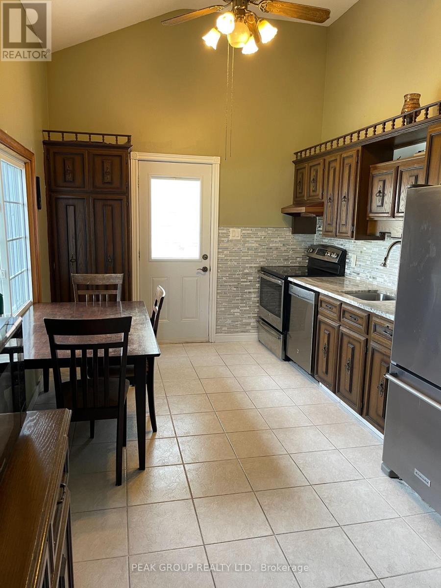 A kitchen with a table and chairs in front of a door.