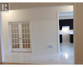 A white interior room with a door and a window.