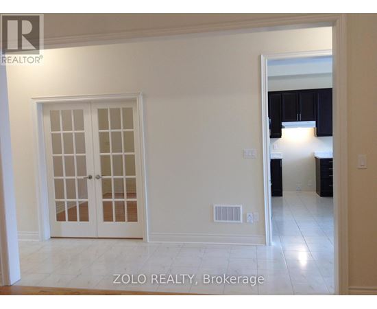 A white interior room with a door and a window.
