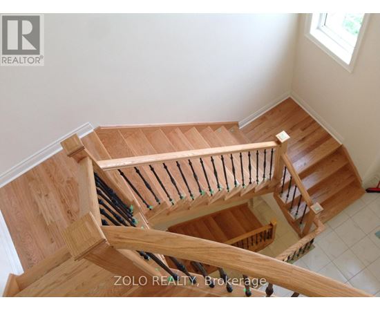 A wooden staircase with a railing and a window.