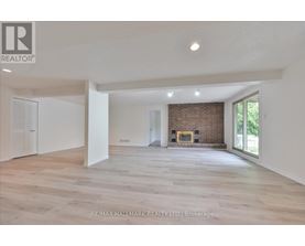 A spacious living room with a fireplace and a large window.
