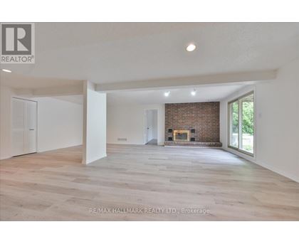 A spacious living room with a fireplace and a large window.