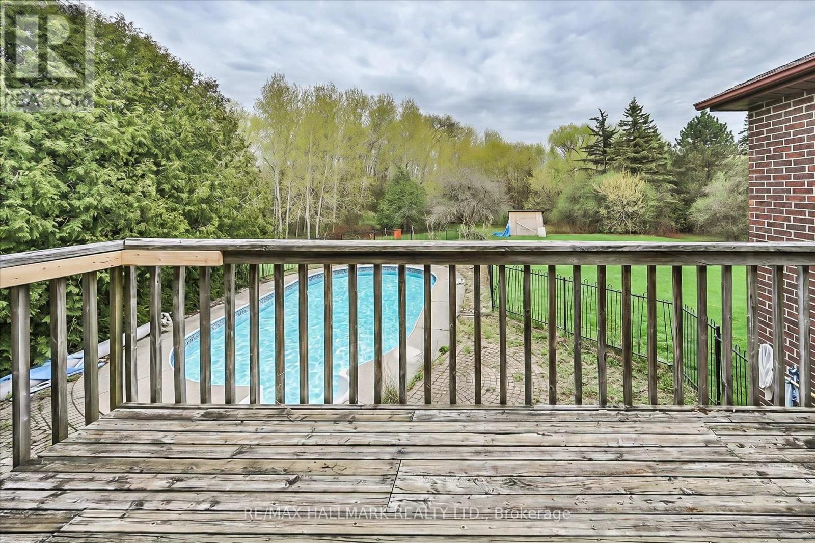 A wooden deck overlooks a blue pool.