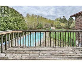 A wooden deck overlooks a blue pool.