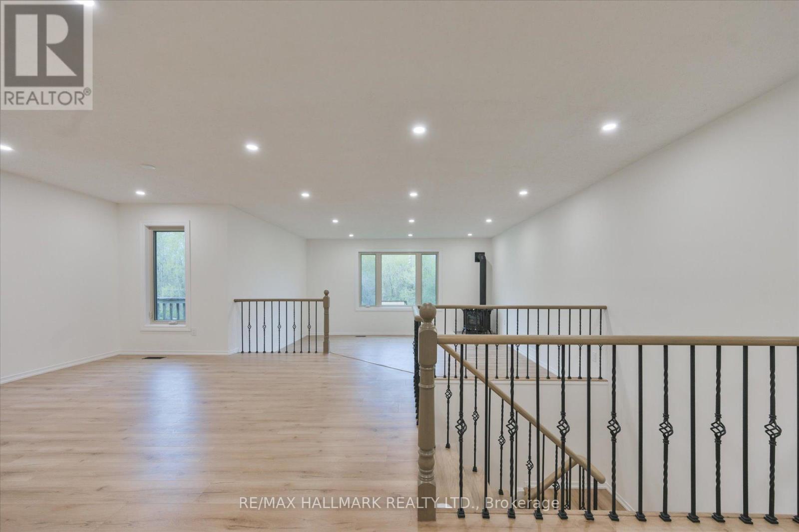 A spacious room with wooden floors and white walls.