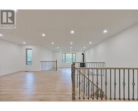 A spacious room with wooden floors and white walls.