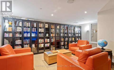 A living room with orange chairs and a bookshelf filled with books.