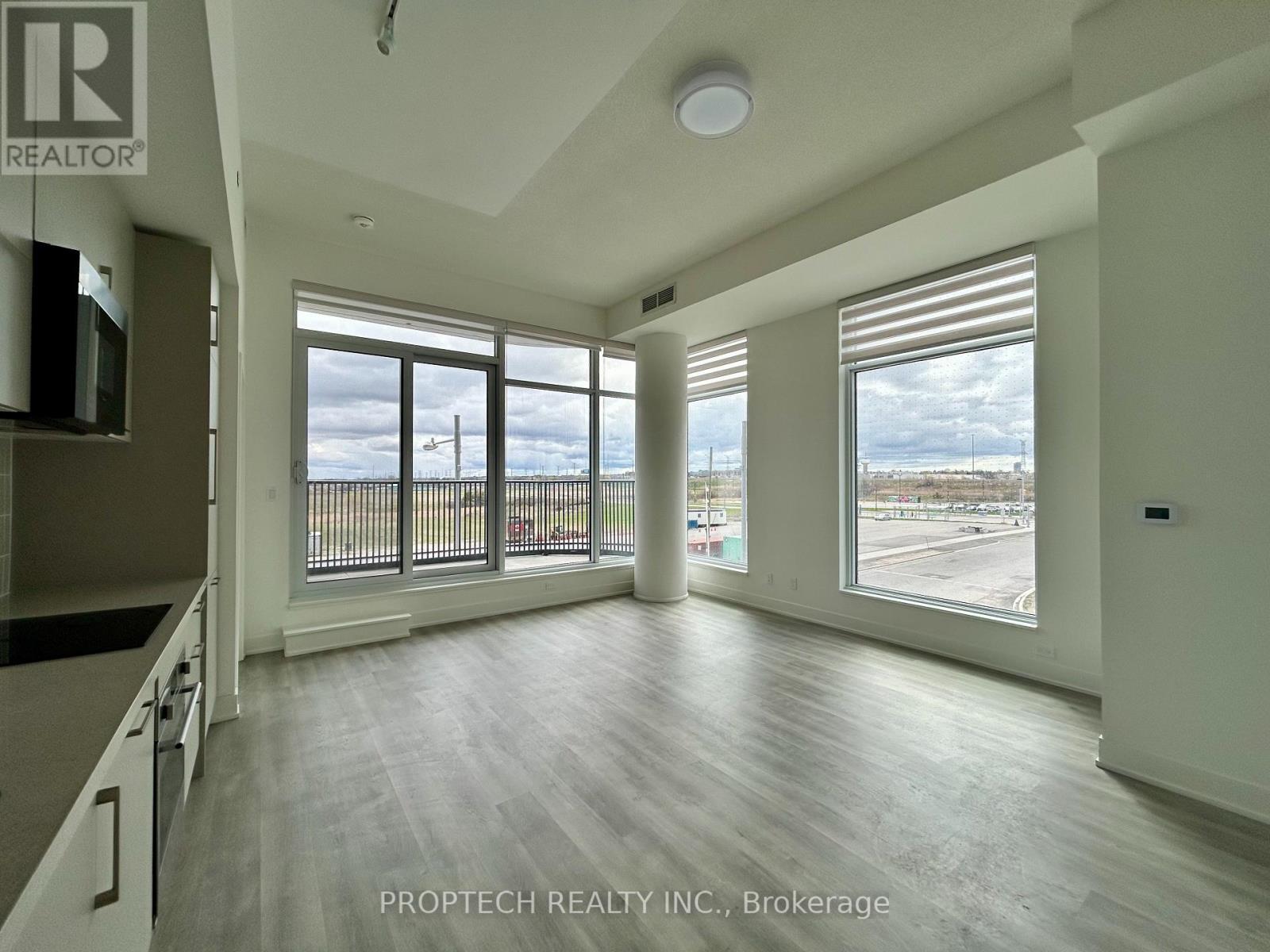 A spacious room with a view of the outside through large windows.