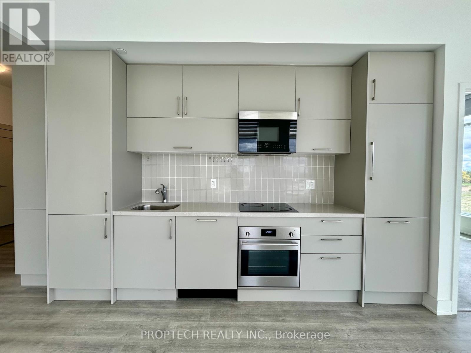 A modern kitchen with white cabinets and appliances.