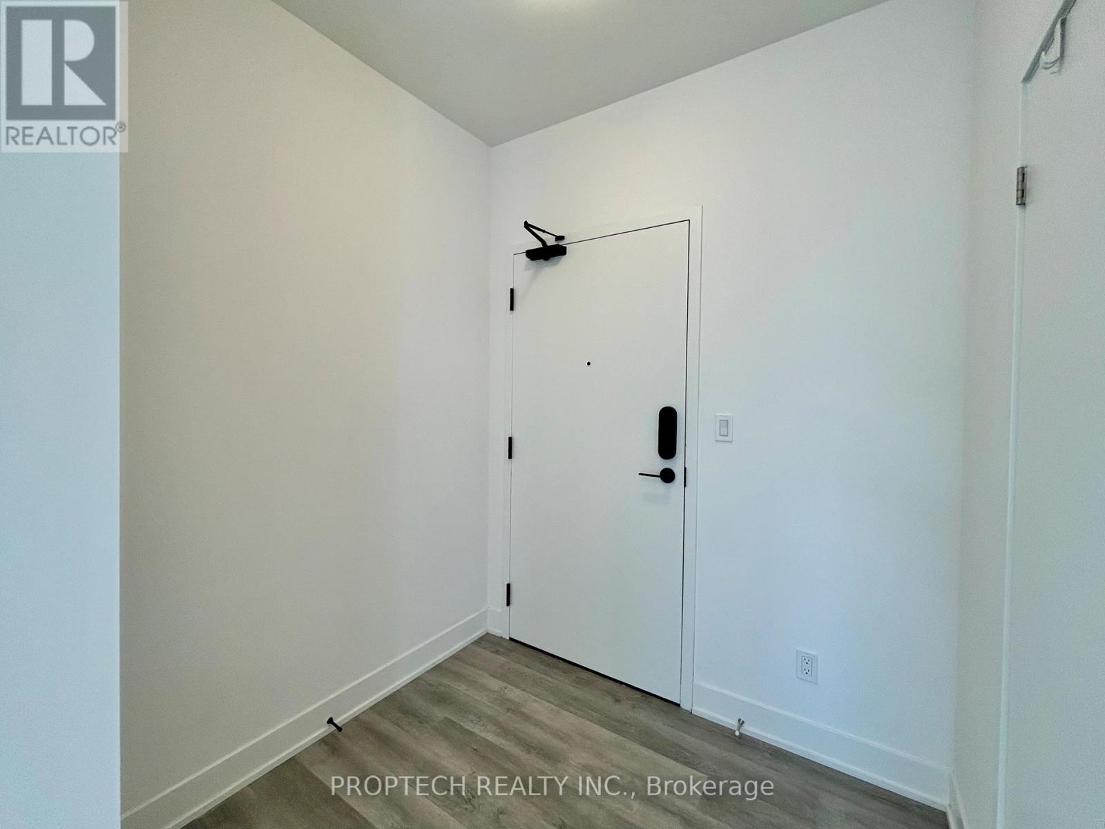 A white door in a room with a ProPtech Realty Inc. logo on the wall.